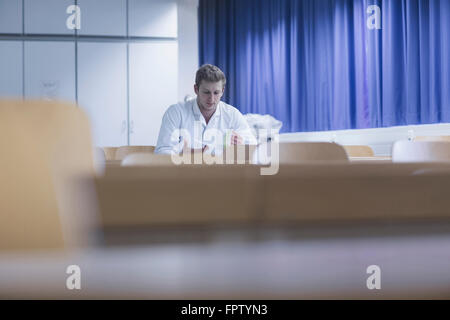 Young male scientist reading book in the lecture room, Freiburg Im Breisgau, Baden-Württemberg, Germany Stock Photo