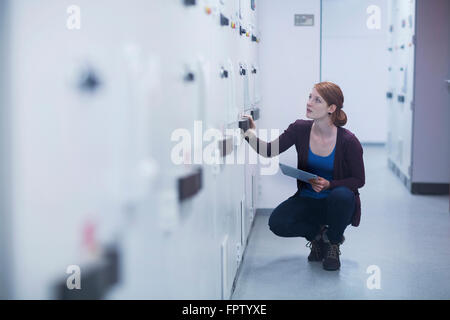 Young female engineer updating control panel by digital tablet in an industry, Freiburg Im Breisgau, Baden-Württemberg, Germany Stock Photo