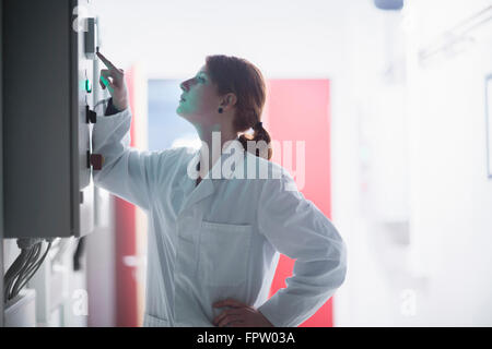 Young female engineer controlling a switch gear in control room, Freiburg Im Breisgau, Baden-Württemberg, Germany Stock Photo