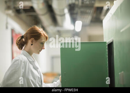 Young female engineer controlling a switch gear in control room, Freiburg Im Breisgau, Baden-Württemberg, Germany Stock Photo