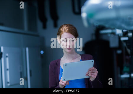 Young female engineer using a digital tablet in an industrial plant, Freiburg Im Breisgau, Baden-Württemberg, Germany Stock Photo