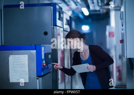 Young female engineer controlling a switchgear in control room, Freiburg Im Breisgau, Baden-Württemberg, Germany Stock Photo