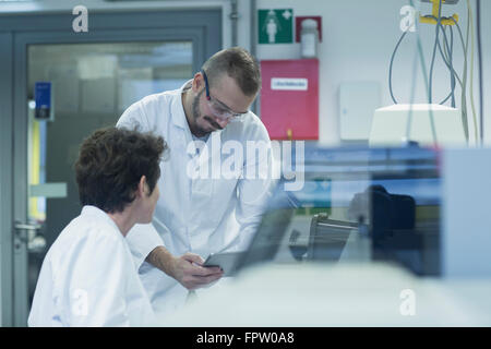 Two scientist working on digital tablet in a pharmacy laboratory, Freiburg Im Breisgau, Baden-Württemberg, Germany Stock Photo