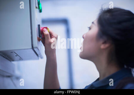Young female engineer operating a switch gear in control room, Freiburg Im Breisgau, Baden-Württemberg, Germany Stock Photo