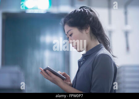 Young female engineer using digital tablet in an industrial plant, Freiburg Im Breisgau, Baden-Württemberg, Germany Stock Photo