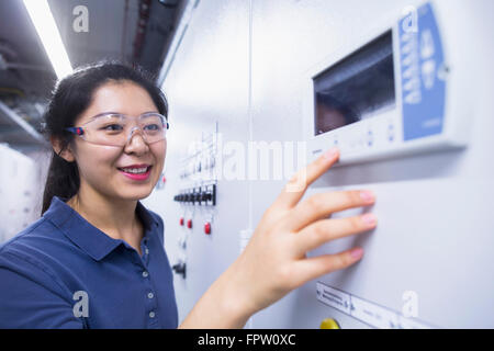 Young female engineer working at control panel in an industrial plant, Freiburg Im Breisgau, Baden-Württemberg, Germany Stock Photo