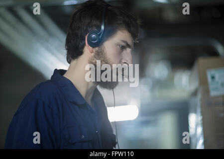 Young male engineer wearing headset and working in an industrial plant, Freiburg Im Breisgau, Baden-Württemberg, Germany Stock Photo