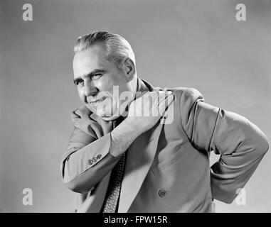 1940s 1950s SENIOR MAN GRIMACE PAIN SHOULDER AND BACK Stock Photo