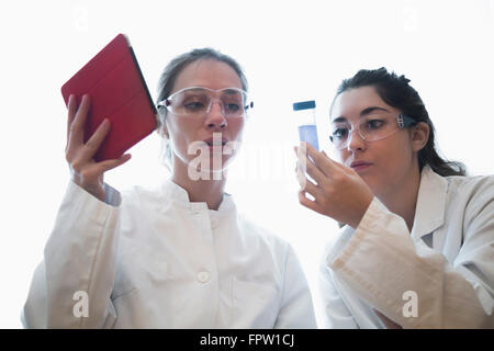 Female scientists in lab coat discussing medical sample, Freiburg Im Breisgau, Baden-Württemberg, Germany Stock Photo