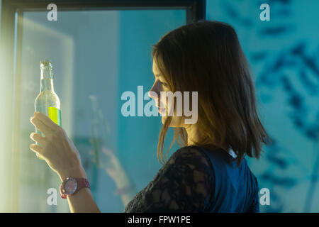 Young woman taking a soda bottle out of refrigerator, Freiburg Im Breisgau, Baden-Württemberg, Germany Stock Photo