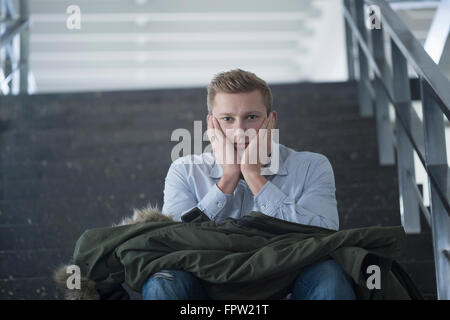 Bored college student sitting alone on staircase, Freiburg im Breisgau, Baden-Württemberg, Germany Stock Photo