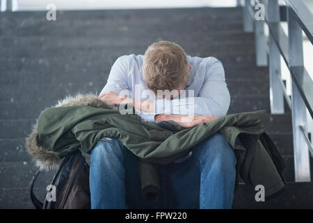Bored college student sitting alone on staircase, Freiburg im Breisgau, Baden-Württemberg, Germany Stock Photo