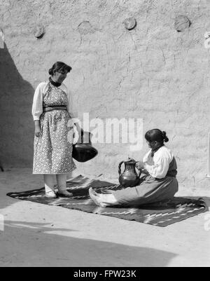 1930s TWO NATIVE AMERICAN INDIAN WOMEN FINISHING POTTERY SANTA CLARA PUEBLO NEW MEXICO USA Stock Photo