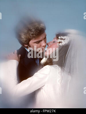 1970s COUPLE BRIDE GROOM WEDDING KISS EMBRACING Stock Photo