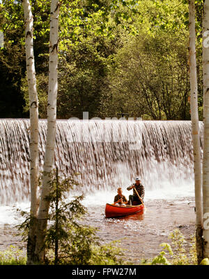 1980s TWO PEOPLE IN CANOE IN FRONT OF A WATERFALL Stock Photo