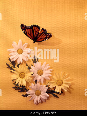 1970s STYLE SEASONAL STILL LIFE DAISIES BUTTERFLY YELLOW WOVEN BACKGROUND Stock Photo