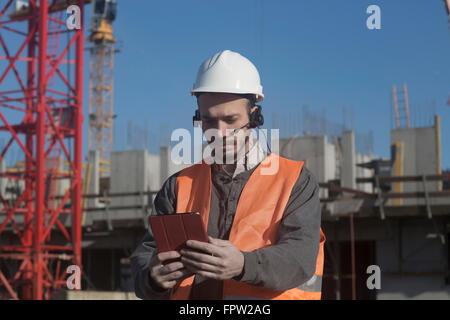 Young male engineer using digital tablet at construction site, Freiburg Im Breisgau, Baden-Württemberg, Germany Stock Photo