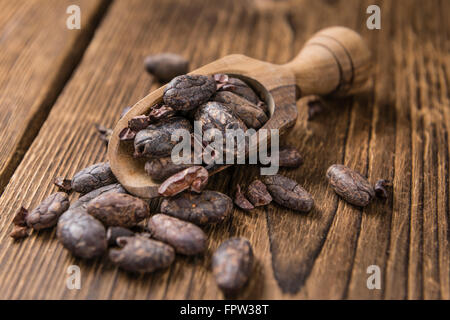 Roasted Cacao Beans (selective focus) on an old wooden table Stock Photo