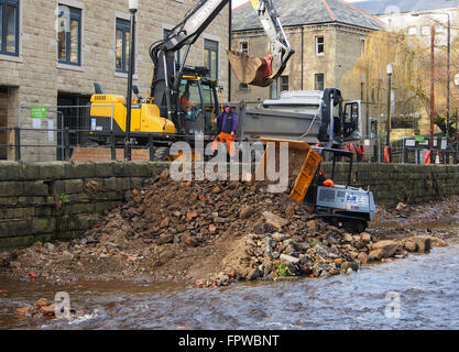 Clearing stones and debris from the floor of the River Calder in Hebden Bridge.  Part of an effort to prevent further flooding. Stock Photo