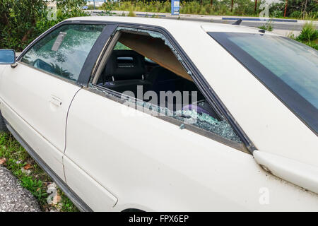 Smashed rear passenger window with broken glass. Stock Photo