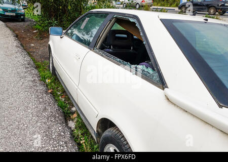 Smashed rear passenger window with broken glass. Stock Photo