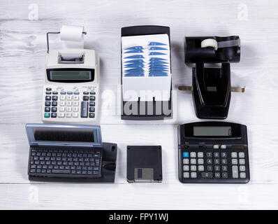 Overhead view of older technology replacing vintage office stationery on white desktop. Stock Photo