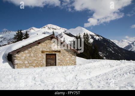 mountain panorama with hut covered in snow, blue sky Stock Photo