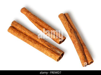 Three cinnamon sticks lie nearby isolated on white background Stock Photo
