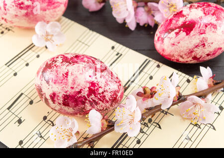 Decorated Easter eggs and fresh cherry blossom tree on sheet lines Stock Photo