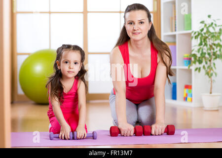 Woman with kid doing gym and fitness exercises Stock Photo