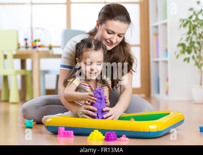 Little Hands Playing Kinetic Sand Molds Red Tra Stock Photo by  ©VladimirNenezic 388802110