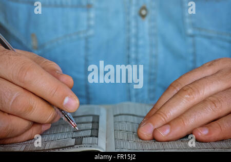 Closeup of two male hands holding a pen over the printed paper Stock Photo