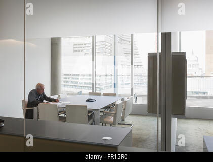 Senior businessman working in modern conference room Stock Photo