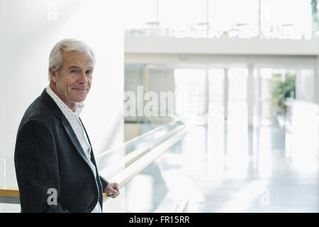 Portrait confident senior businessman in modern lobby Stock Photo