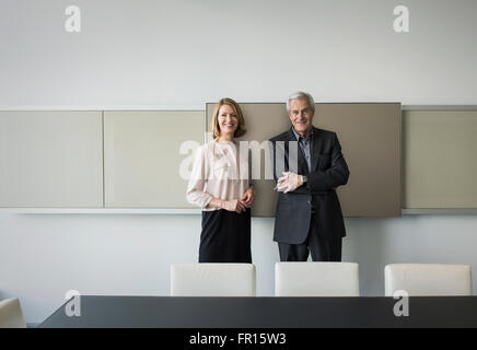 Portrait confident businessman and businesswoman in conference room Stock Photo