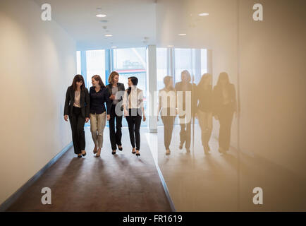 Businesswomen walking in a row in office corridor Stock Photo