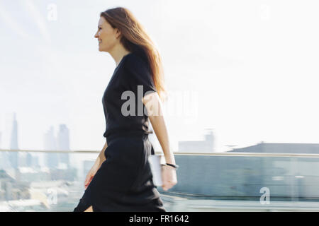 Businesswoman on the move on urban balcony Stock Photo