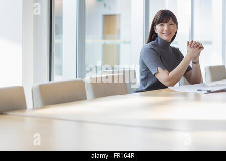 Portrait confident businesswoman at conference table Stock Photo
