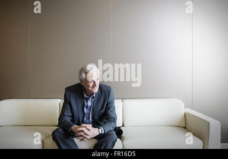 Senior man on sofa looking away Stock Photo