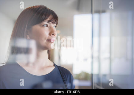 Pensive businesswoman looking out window Stock Photo