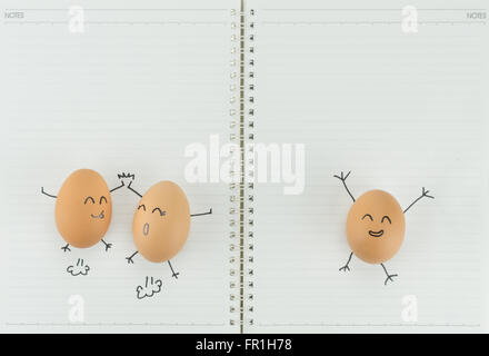 Three happy eggs with copy space on blank notebook paper Stock Photo