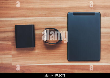 Flat lay of clever new technology of today - portable charger powerbank, smart wrist watch, tablet pc. Travel and stay connected Stock Photo