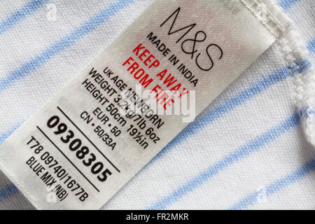 label in young newborn baby's M&S babygro  - keep away from fire Made in India - sold in the UK United Kingdom, Great Britain Stock Photo