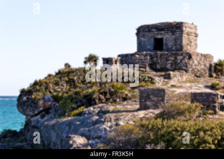 Blurred background of Mayan ruins perched on a cliff above the ocean at Tulum, Quintana Roo, Mexico. Stock Photo