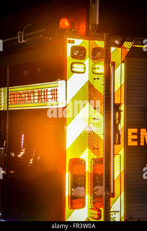 Detail at night of a fire engine EMS truck with flashing lights attending to an emergency Stock Photo