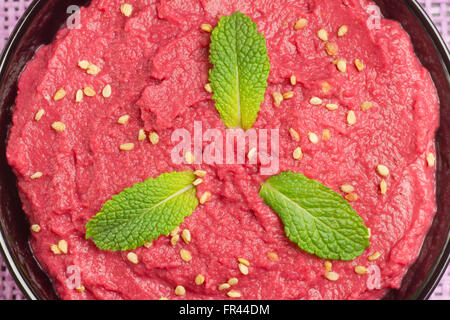 Close up of a beet hummus on purple background Stock Photo