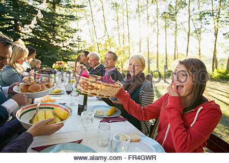 Three generations of family eating outdoors.