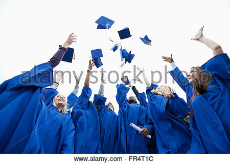 Female graduate at her convocation, throwing her graduation hat in the ...