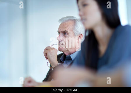 Focused senior businessman listening in meeting Stock Photo