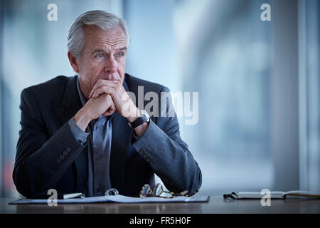 Pensive senior businessman looking away in conference room Stock Photo